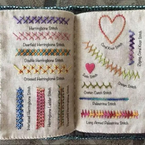 Open embroidery book with herringbone, heart and chain stitch samples