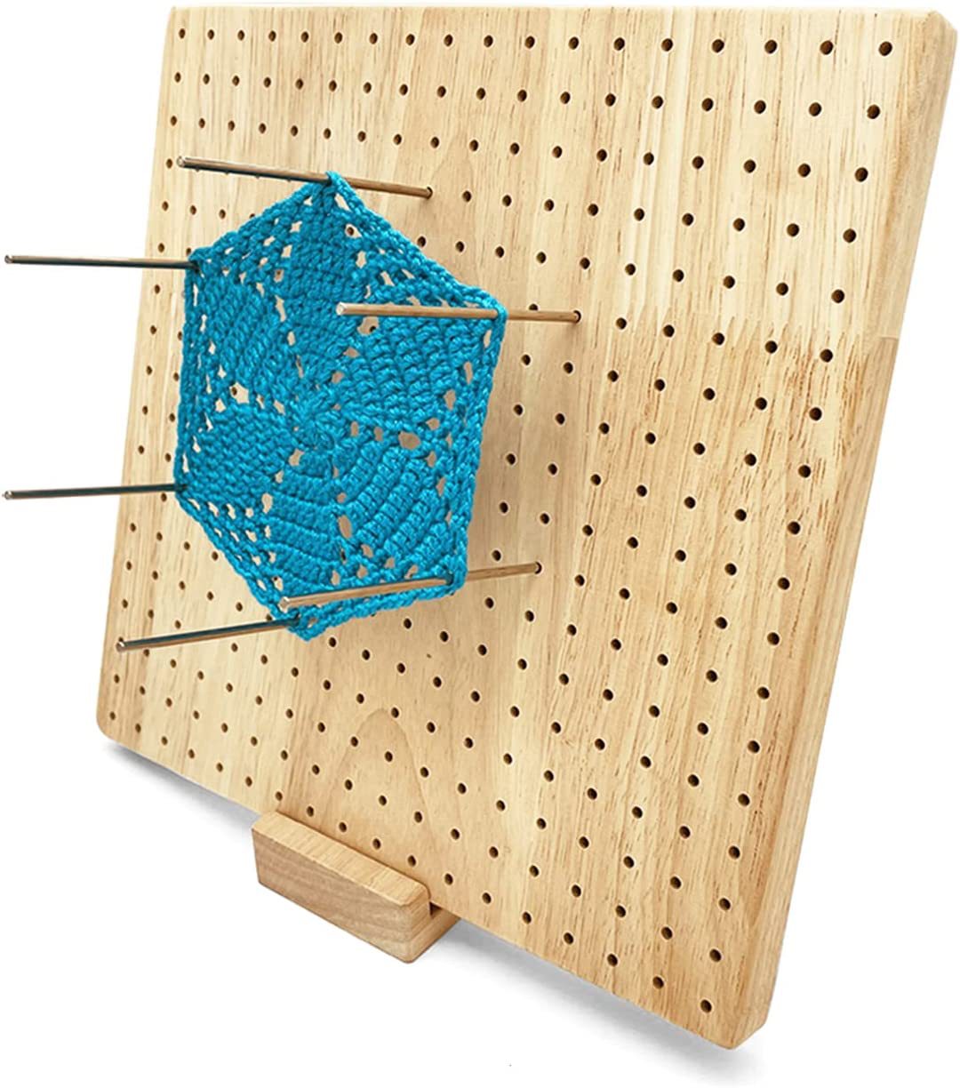 Blue crochet hexagon pinned to an upright blocking board