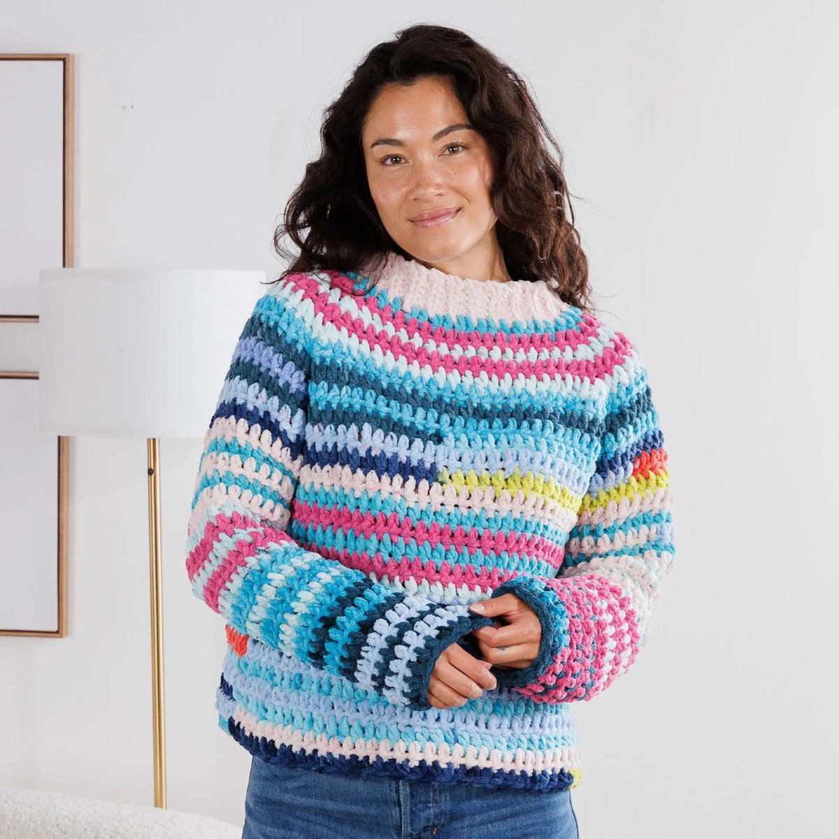 Model wearing the blue, pink and cream Bernat Patchwork crochet pullover