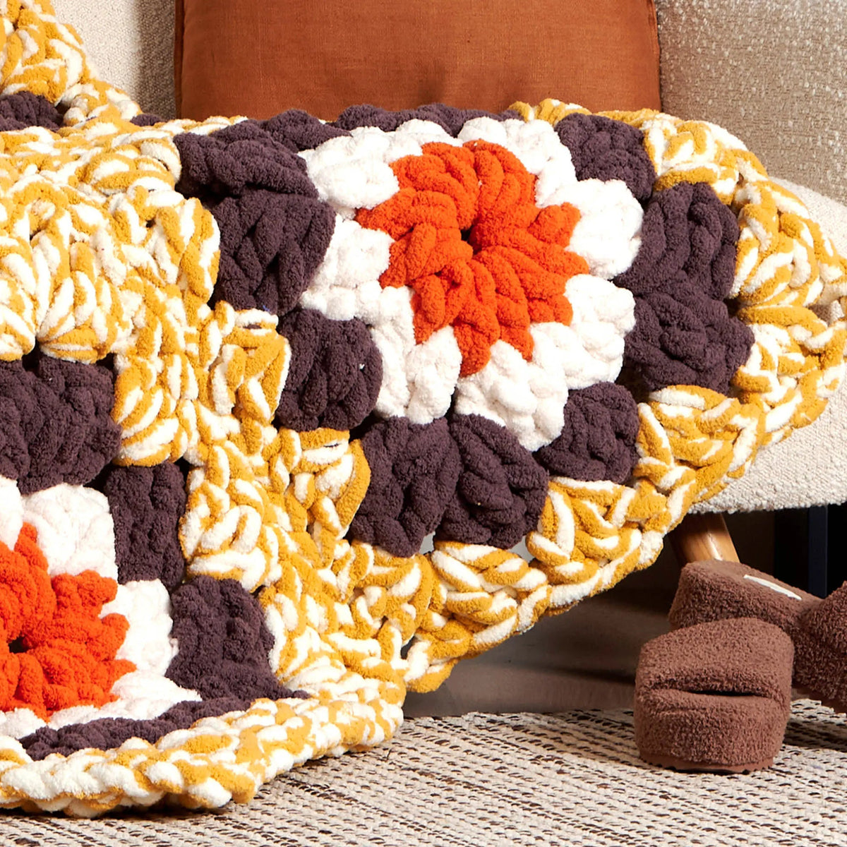 Close-up of a flower-like granny square in a draped blanket