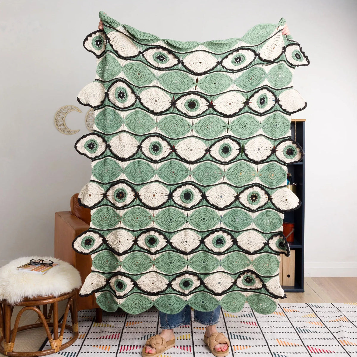 Eye-motif crochet blanket held upright