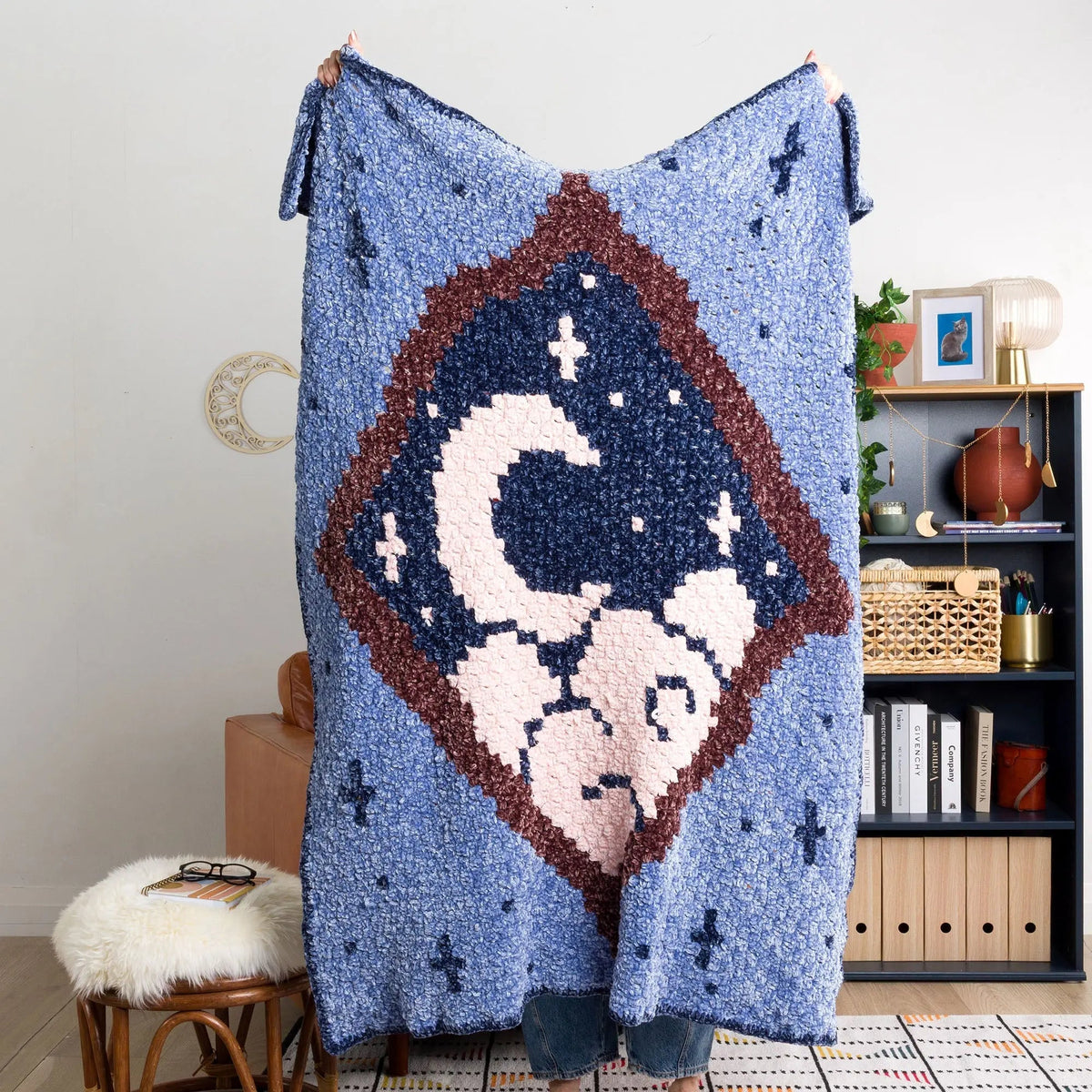 Person holding the Moonlit View crochet blanket open
