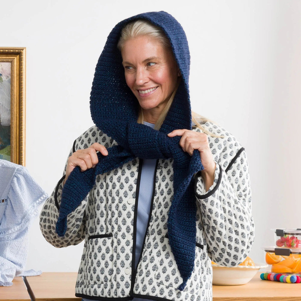 Model adjusting a navy hooded scarf
