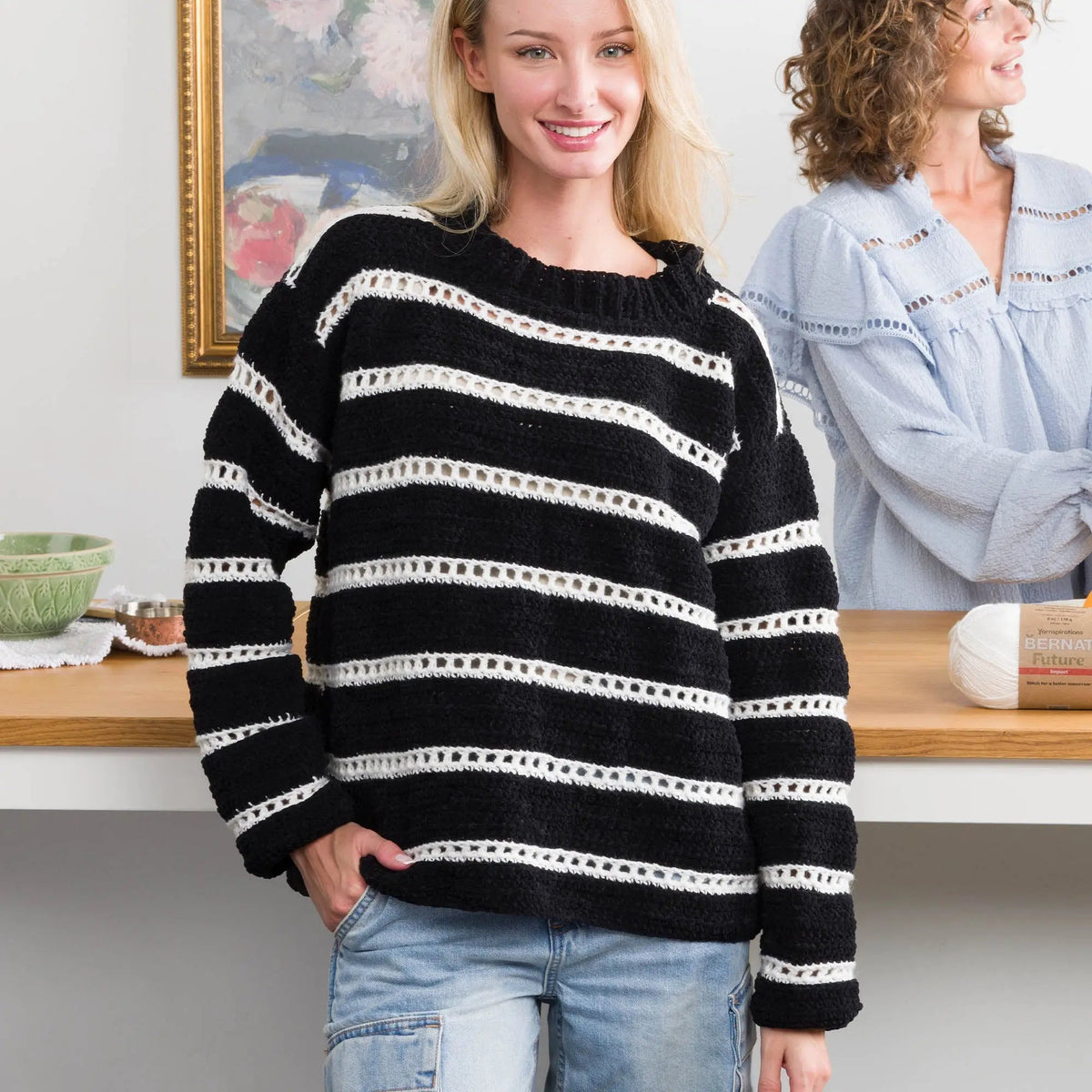 Model wearing a black and white eyelet-stripe crochet pullover
