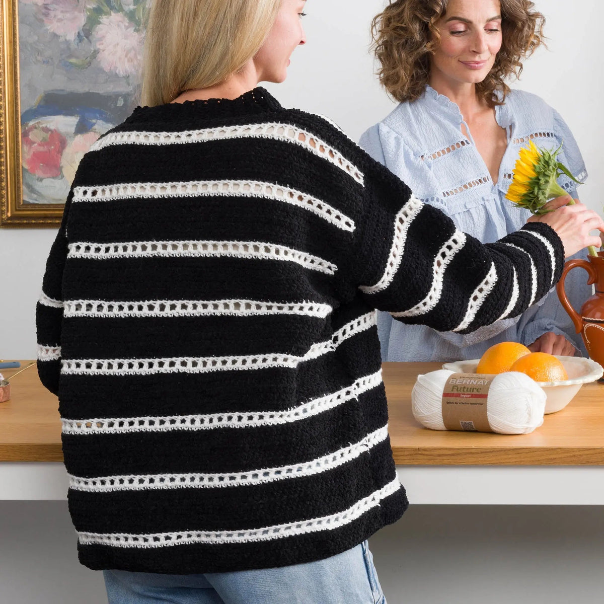 Back of the black and white crochet pullover worn by a model