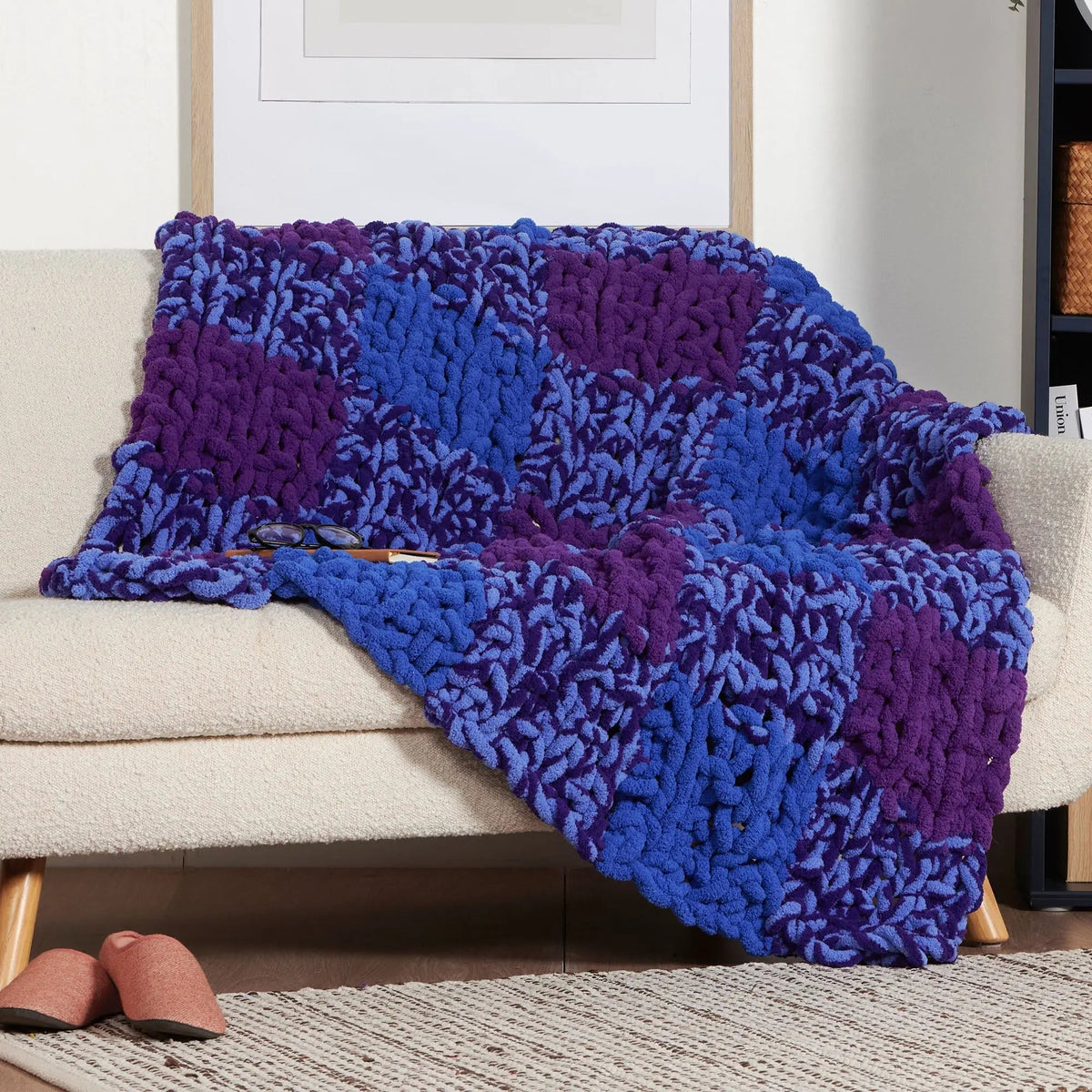 Blue and purple gingham knit blanket draped over a seat