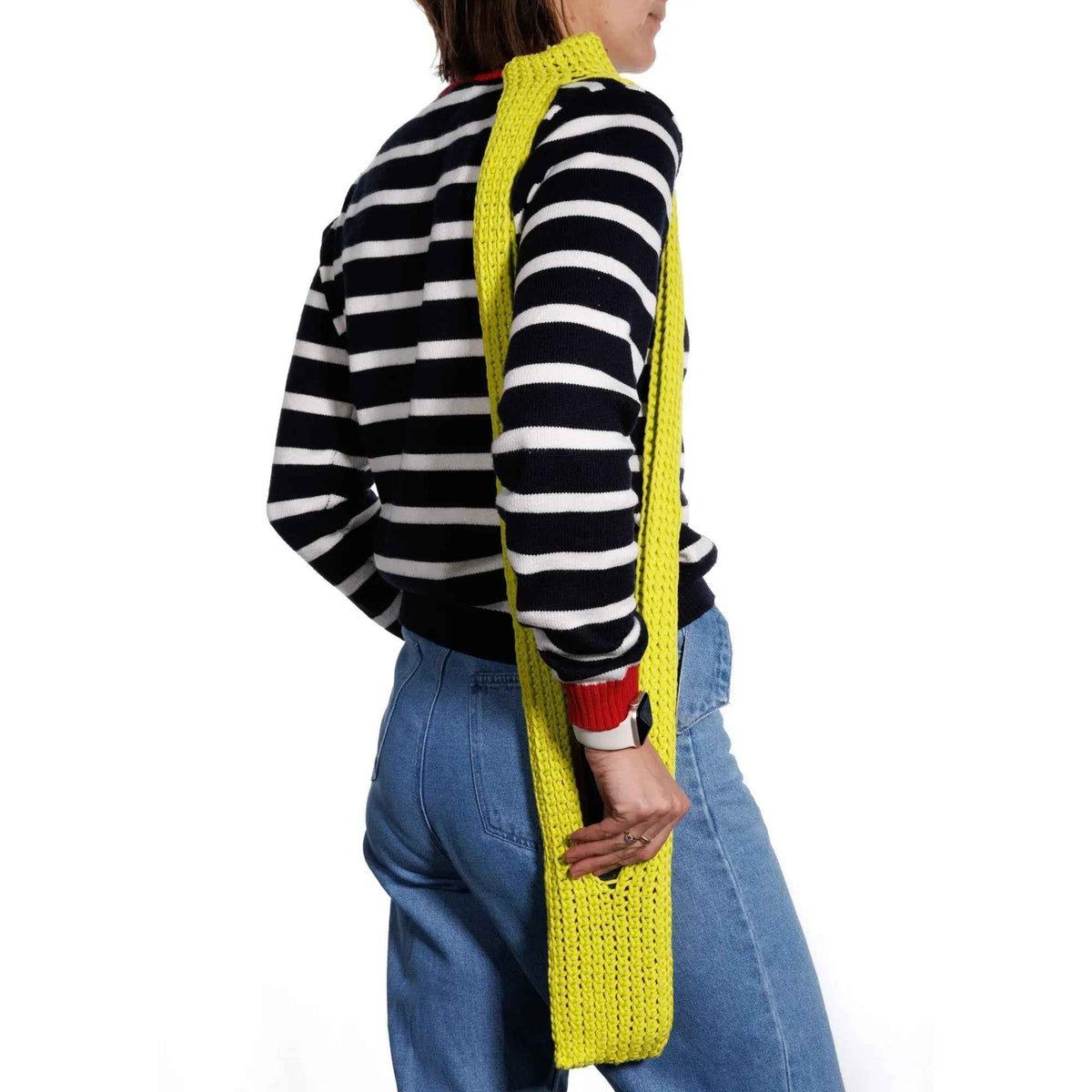 Model wearing the yellow crochet phone pouch across the body
