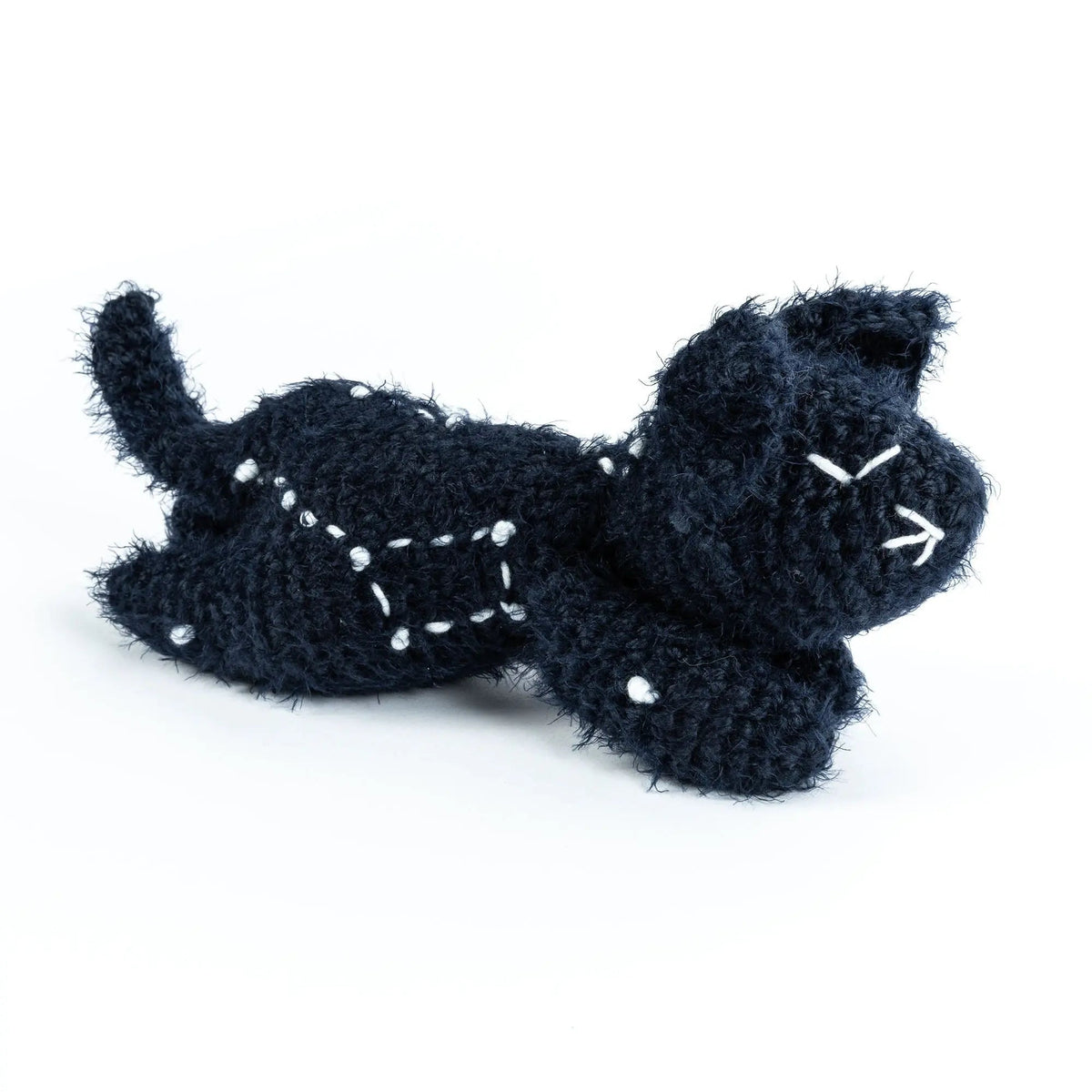 Side view of the sleeping crochet cat with white constellation embroidery
