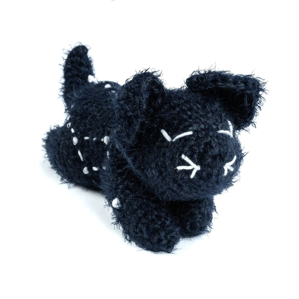 Front of the crochet cat with closed embroidered eyes