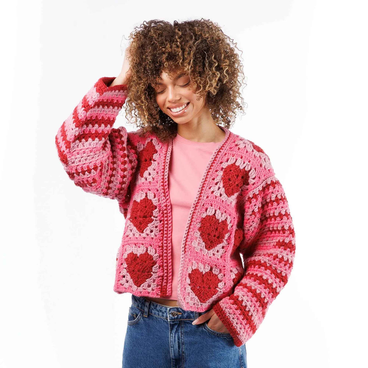 Model wearing a pink and red heart-motif crochet cardigan