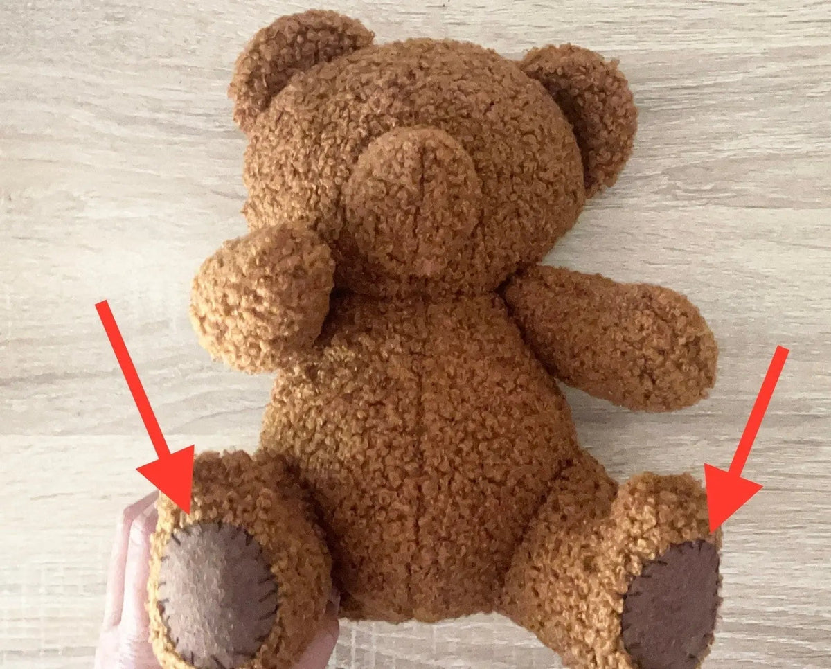 Close-up of teddy bear foot pads with seam-detail arrows