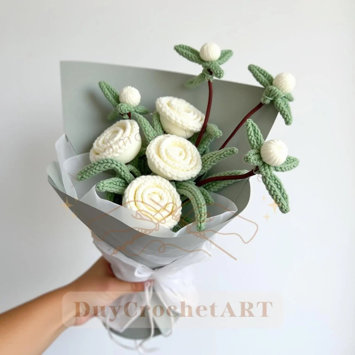 White crocheted rose bouquet with green leaves