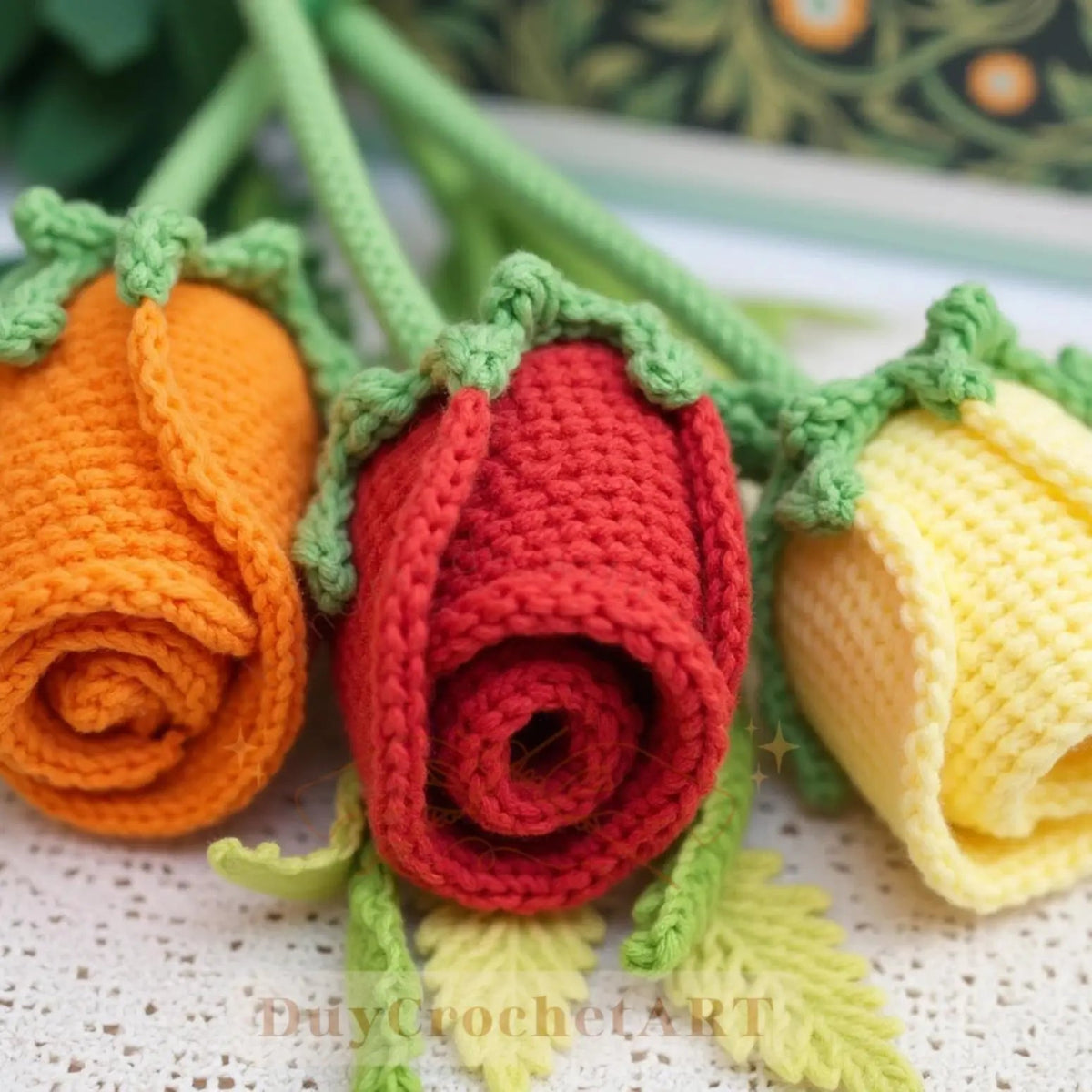 Rolled crochet roses in yellow, red and orange