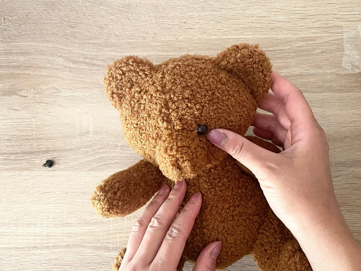 Hands holding a brown teddy bear